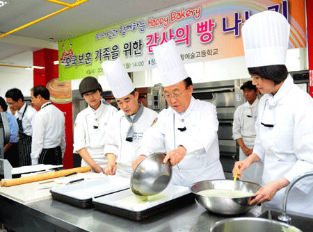 김관용 경북 도지사가 '호국보훈 가족을 위한 감사의 빵 나누기' 행사에서 청소년들과 함께 롤 케이크를 만들고 있다.