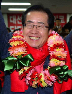 홍준표 경남도지사 당선인이 19일 오후 창원시 성산구 중앙동 선거사무실에서 지지자들이 전해준 축하 꽃다발을 목에 걸고 환하게 웃고 있다.