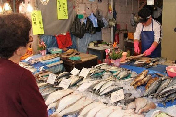 전통시장에서 수산물을 구매하고 있는 소비자
