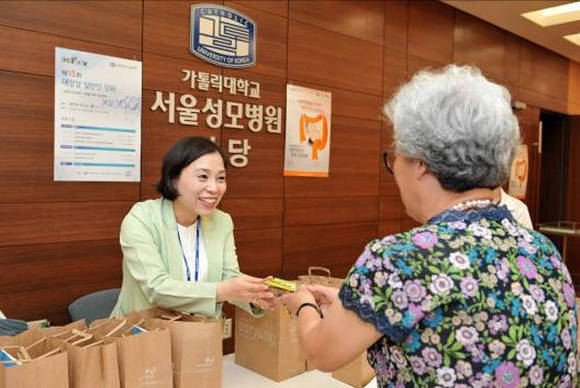 지난달 서울성모병원서 열린 골드리본 캠페인 건강강좌에서 참석자들에게 장 건강에 좋은 키위를 나눠주고 있다