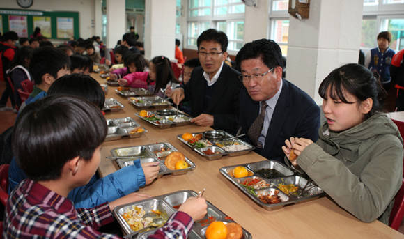 강인규 나주시장이 17일 영산포초등학교에서 배식을 한 뒤 학생들과 식사를 하며 얘기를 듣고 있다