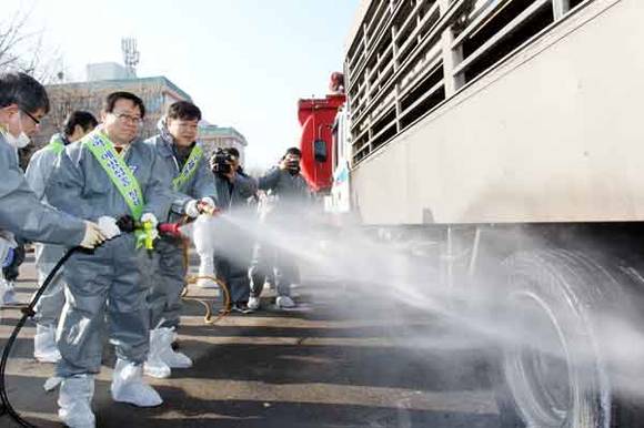 이동필 농림축산식품부장관이 가축운반차량에 직접 소독을 시연하고 있다.