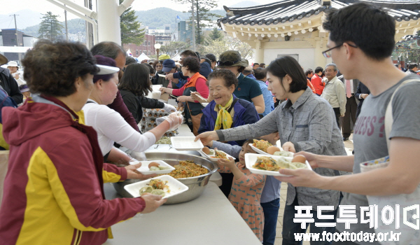 지난 14일부터 시작된 ‘제33회 수안보 온천제’가 2일차인 15일 ‘꿩 산채비빔밥’ 퍼포먼스 행사를 열어 수안보만의 환상의 음식을 선보였다. 사진은 축제에 참여한 시민과 관광객들이 뀡 산채비빔밥을 받고 있는 모습.