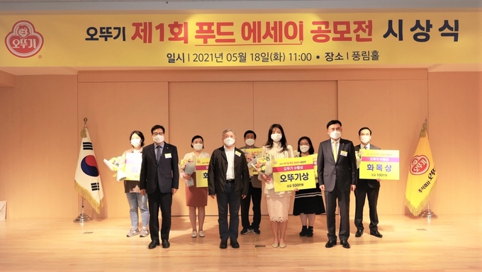 오뚜기 제1회 푸드 에세이 공모전 수상자 기념촬영 모습 <br>
(사진설명 : 앞줄 좌측부터 최원현 심사위원장, ㈜오뚜기 함영준 회장, 오뚜기상 남명혜씨, 뒷줄 좌측부터 화목상 유가희씨, 화목상 김지연씨, 으뜸상 김경진씨, 화목상 성기용씨, 화목상 박성근씨)