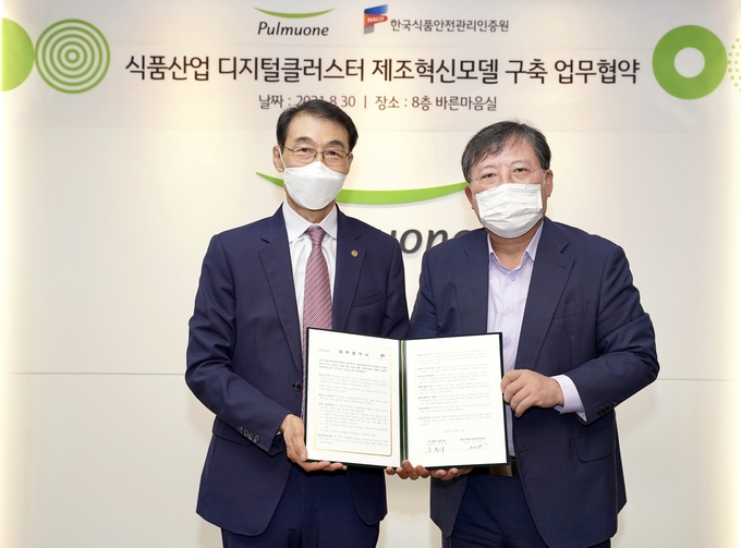 HACCP인증원 조기원 원장(左)과 ㈜풀무원 이효율 총괄CEO(右)가 업무협약서에 서명한 다음 기념촬영하고 있다.