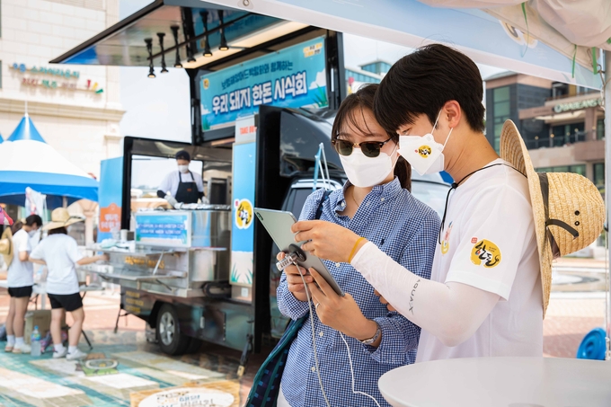 충남 보령 대천해수욕장 일원에서 열린 ‘2022 보령해양머드박람회, 다 함께 한돈!’ 행사장을 찾은 관광객이 한돈 퀴즈를 풀고 있다. 