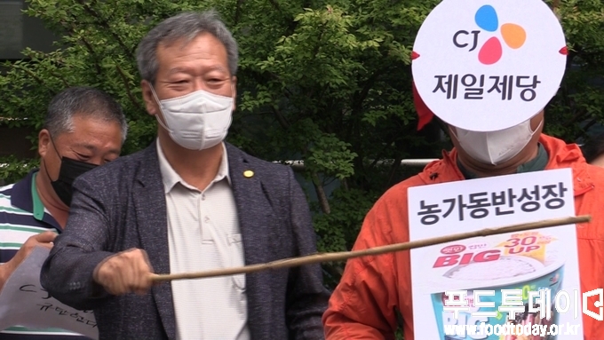 <strong>하원오 전국농민회총연맹 의장이 CJ제일제당에 회초리로 치는 퍼포먼스를 하고 있다.</strong>