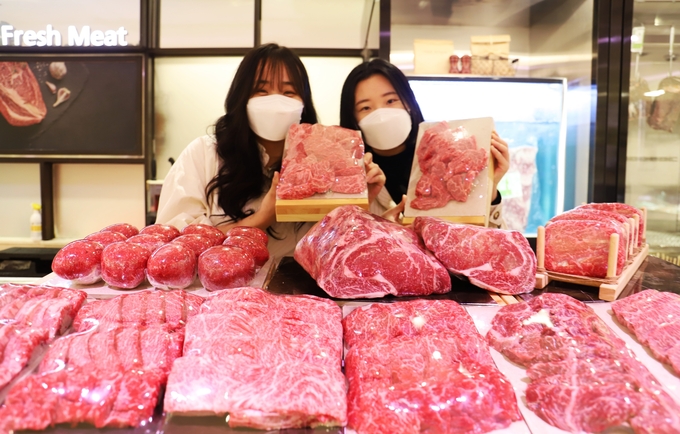 롯데백화점 본점 식품관에서 모델들이 '한우 특별 기획전' 행사를 홍보하고 있다.