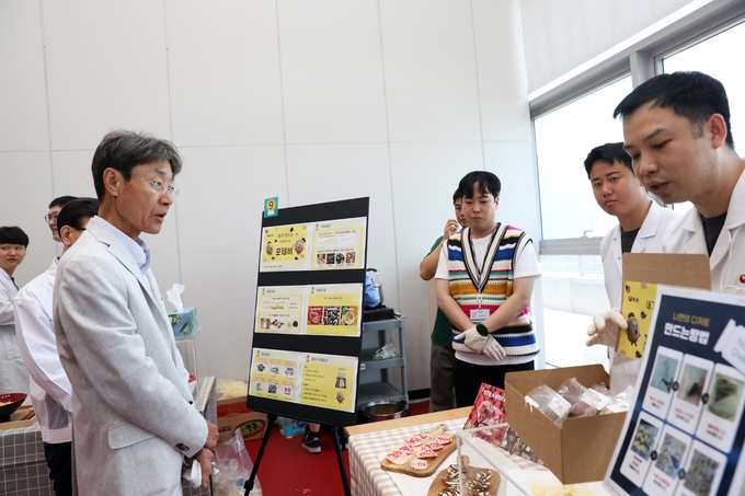 농심 신동원 회장이 사내 아이디어공모전 '챌린지페어'에서 연구원들의 신제품 아이디어를 듣고 있다 (농심 제공)
