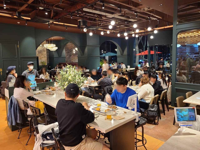 BBQ 빌리지 송리단길점에서 고객들이 치킨과 맥주를 즐기고 있다 (제너시스BBQ 제공)