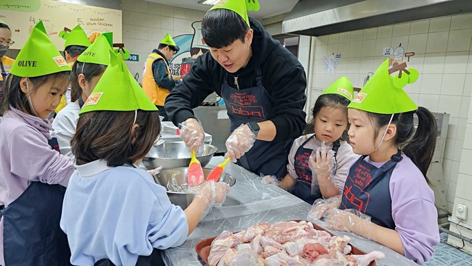 BBQ 치킨대학의 치킨캠프에 참여한 대한적십자사 청소년적십자(Red Cross Youth, RCY) 봉사단원들이 BBQ 황금올리브 치킨을 직접 만들고 있다 (제너시스BBQ 제공)