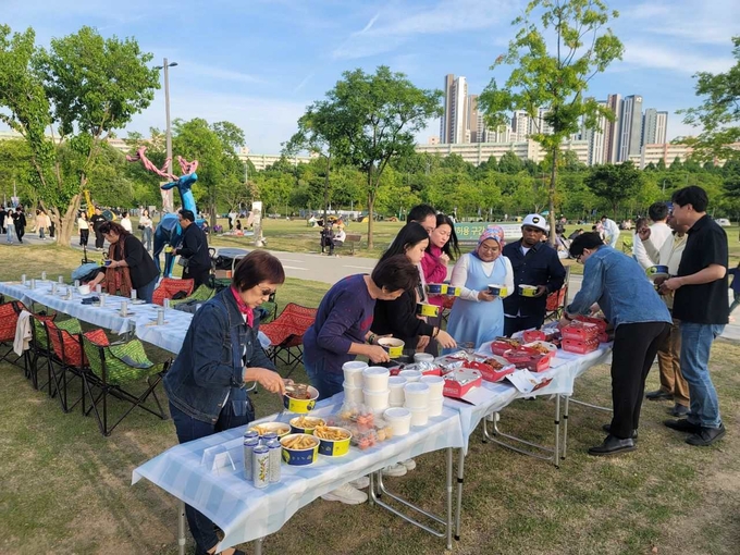 K-치킨을 맛보기 위해 한국을 찾은 말레이시아 유튜버들이 반포 한강공원 달빛 무지개 분수 인근에서 BBQ 치맥을 즐기고 있다 (제너시스BBQ 제공)