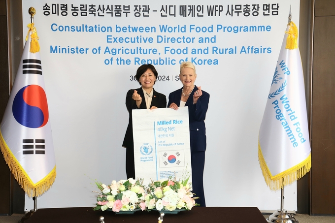 우리나라의 식량원조 쌀이 담기는 포장재를 들고 기념사진을 촬영 중인 농식품부 송미령 농림축산식품부 장관과 WFP 신디 매케인 사무총장 (농림축산식품부 제공)