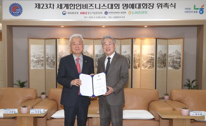 강호동 농협중앙회장(사진 오른쪽)과 이상덕 재외동포청장이 4일 서울시 중구 농협중앙회 본관에서 열린 제23차 세계한인비즈니스대회 명예대회장 위촉식에서 기념사진을 촬영하고 있는 모습