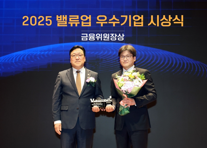 27일 오후 서울 여의도 한국거래소에서 열린 '2025 밸류업 우수기업 시상식'에서 장석훈 삼양식품 경영지원본부장(오른쪽)과 김병환 금융위원회 위원장(왼쪽)이 기념 촬영을 하고 있다. 삼양식품은 이날 기업 가치 제고 노력과 성과를 인정받아 밸류업 우수기업으로 금융위원장상을 수상했다. (삼양식품 제공)