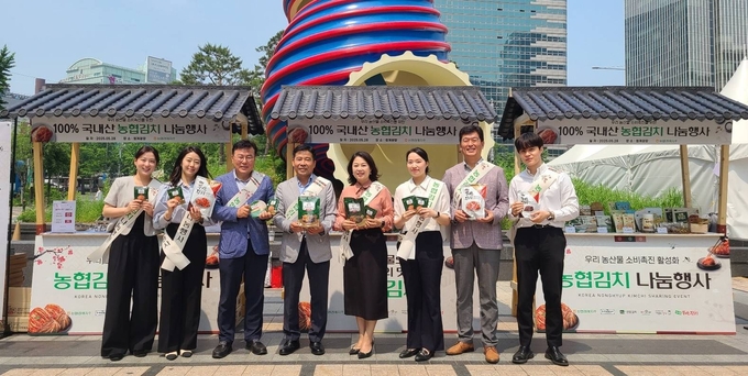 서승일 한국농협김치조공법인 사업전무(왼쪽에서 4번째)와 장지윤 농협경제지주 식품지원부장(왼쪽에서 5번째)이 28일 서울시 중구 청계광장에서 국산 김치의 우수성을 알리기 위한 농협김치 나눔행사를 개최하고 기념사진을 촬영하고 있다.