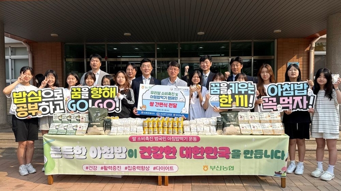 이수철 농협중앙회 부산본부장(첫번째 줄 왼쪽에서 7번째)과 유국종 부산광역시교육청 인성체육급식과장(첫번째 줄 왼쪽에서 8번째)이 28일 아침 걷기운동 프로그램에 참여하는 학교에 쌀 간편식을 전달하며 학생들과 기념사진을 촬영하고 있다.