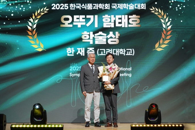 2025 한국식품과학회 국제학술대회에서 (재)오뚜기함태호재단 박기문 이사(좌)와 오뚜기 함태호 학술상을 수상한 고려대학교 한재준 교수가 기념촬영을 하고 있다.