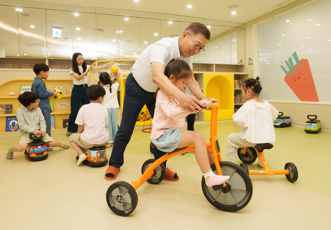 풀무원 이우봉 총괄CEO가 원아들과 놀이에 참여하며 밝게 웃고 있다.
