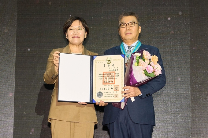 풀무원 이우봉 총괄CEO가 29일 서울 삼성 코엑스에서 열린 ‘푸드위크 코리아 2025’에서 국내 식품산업의 성장 및 발전에 기여한 공로를 인정받아 '은탑산업훈장'을 받았다. 이우봉 총괄CEO(오른쪽)가 송미령 농림축산식품부 장관(왼쪽)과 기념 촬영을 하고 있다.